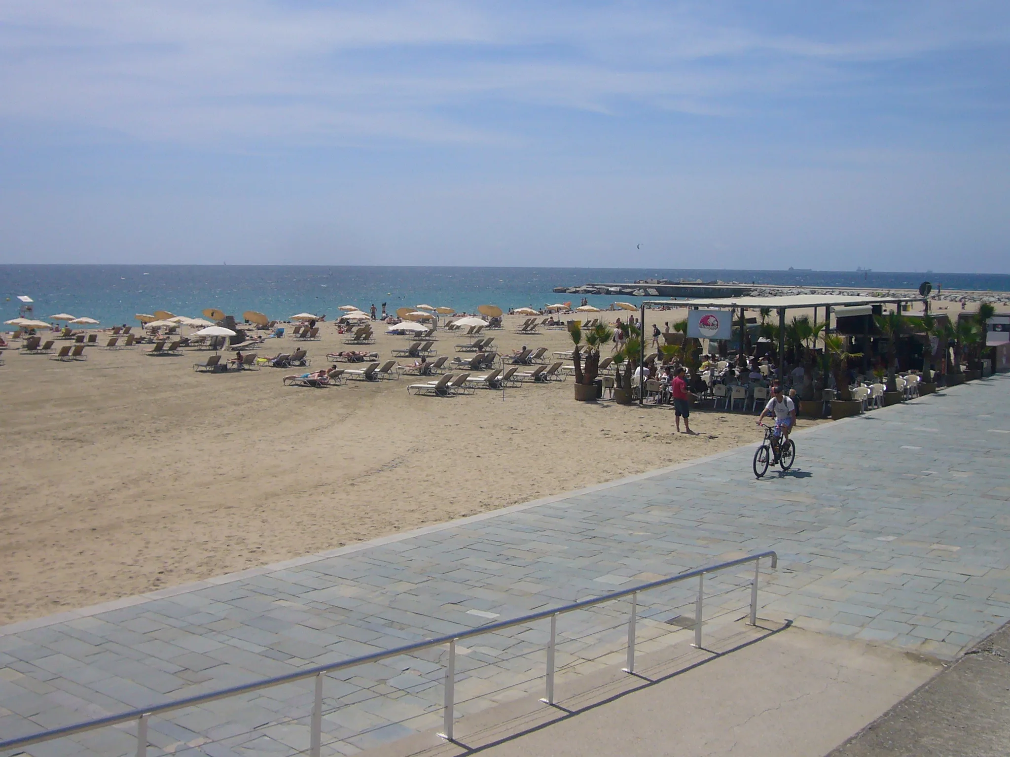 Het brede en rustigere strand van Bogatell in Barcelona met de Poblenou-wijk op de achtergrond