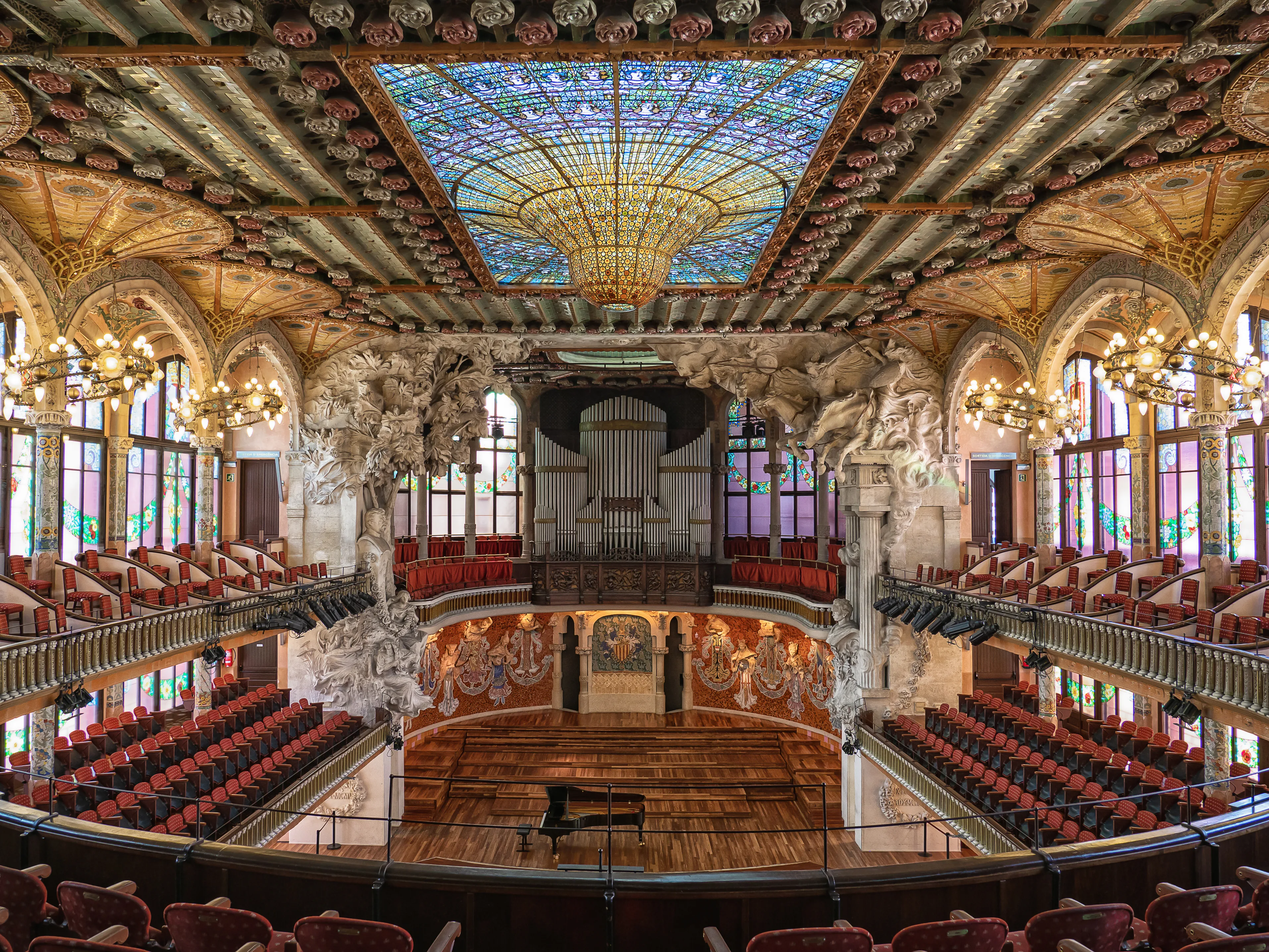Het verlichte interieur van het Palau de la Música Catalana met het centrale glazen koepelgewelf vol kleur