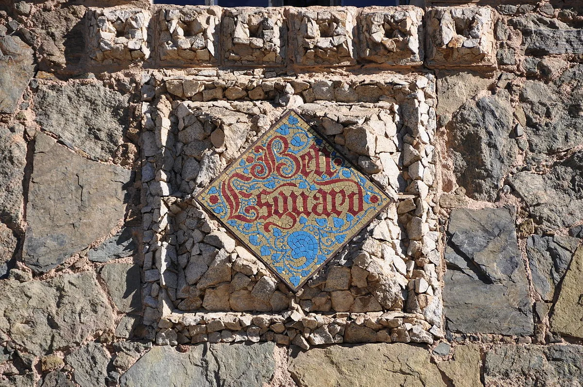 Het ingegraveerde keramische naambordje van Torre Bellesguard op de middeleeuwse stenen muur van Gaudís kasteel in Barcelona